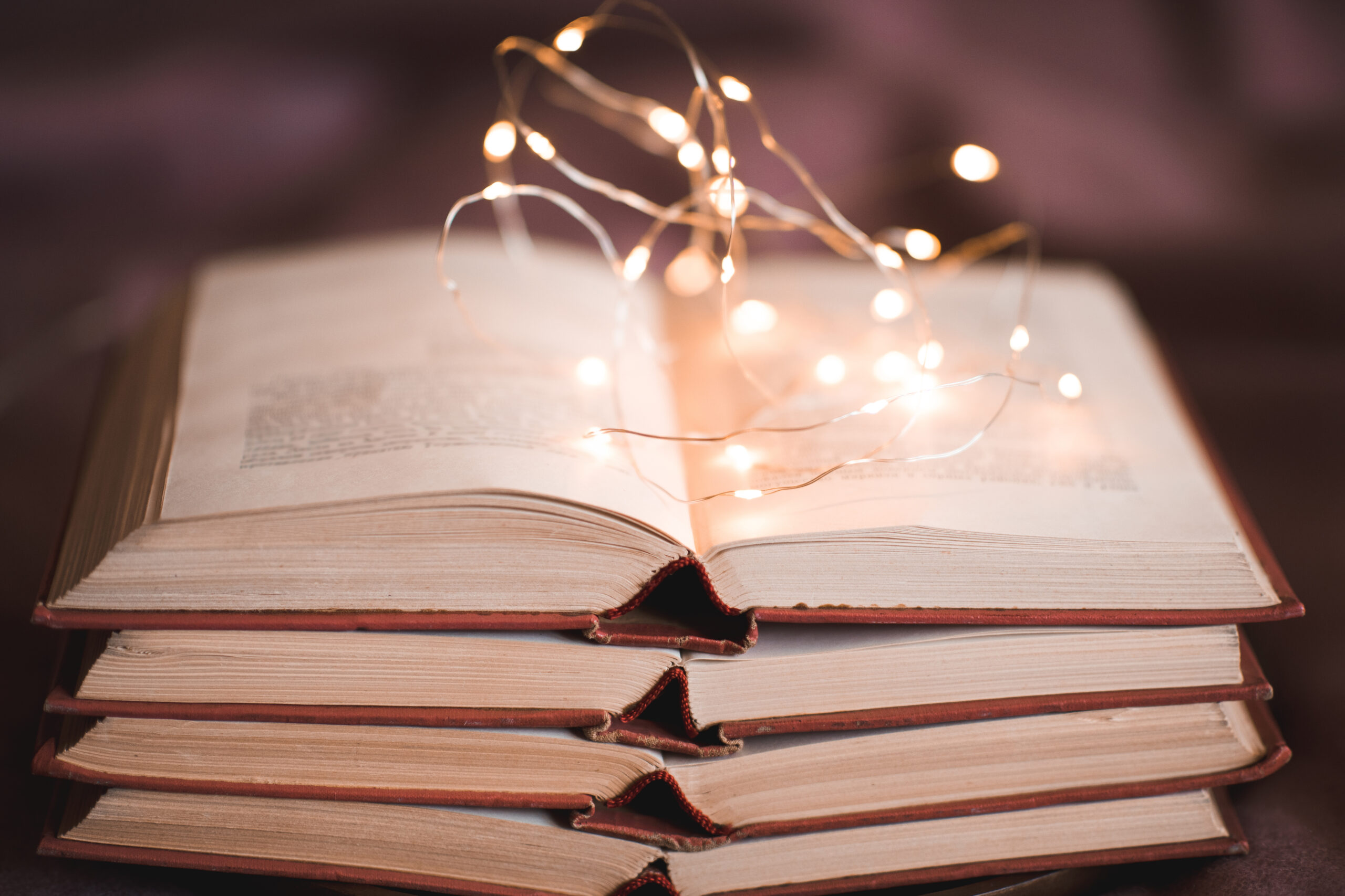 Stack of old books with lights closeup. Home library. Education concept.